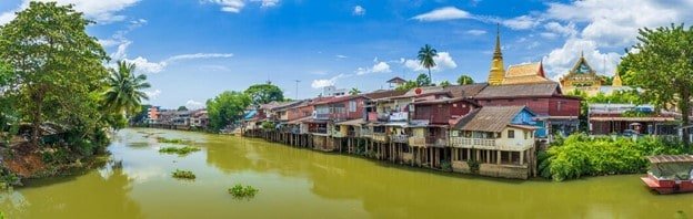 The Zuri Kumarakom, Kerala ; A luxurious resort in South India, with a view of the ocean, palm trees, and lush green forests.